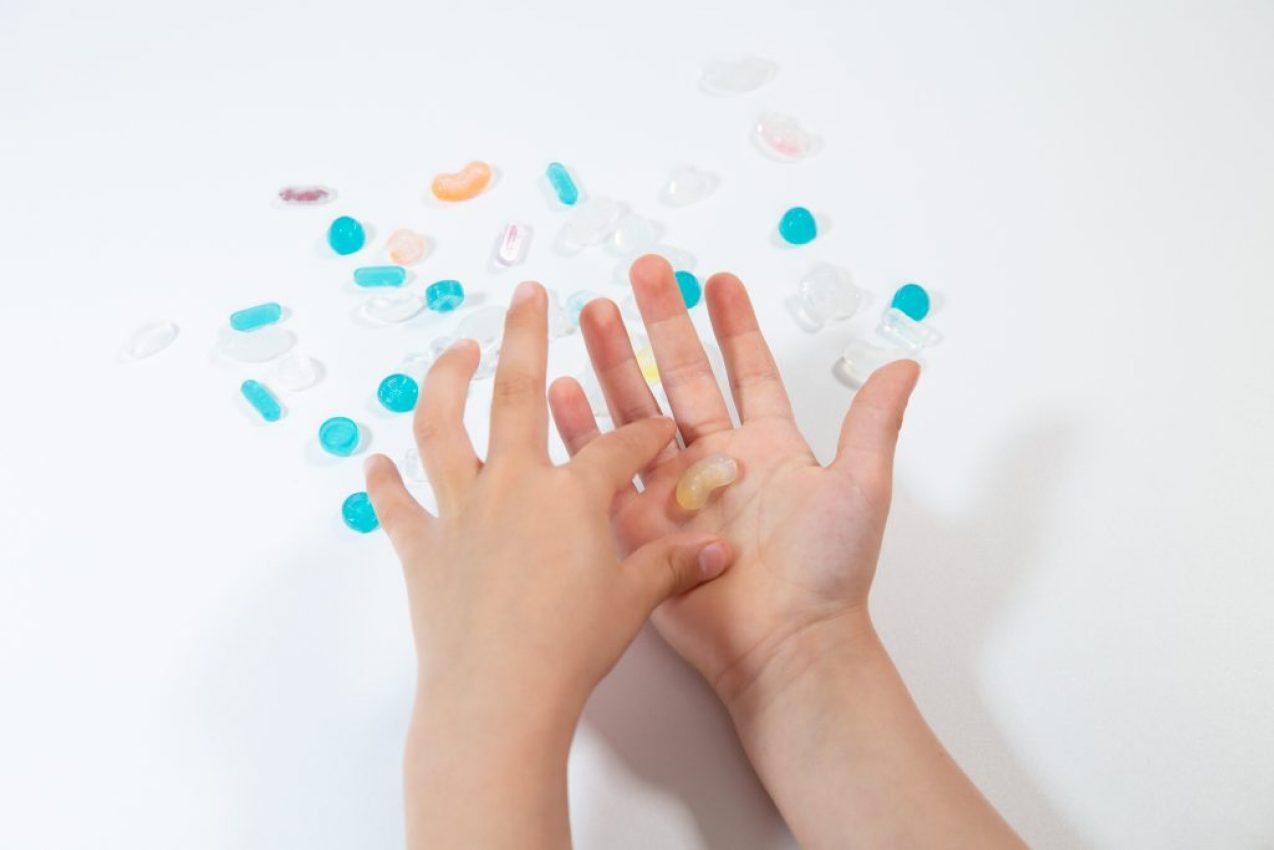 Main d'enfant qui tient un médicament personnalisé fabriqué par impression 3D adapté à ces besoins